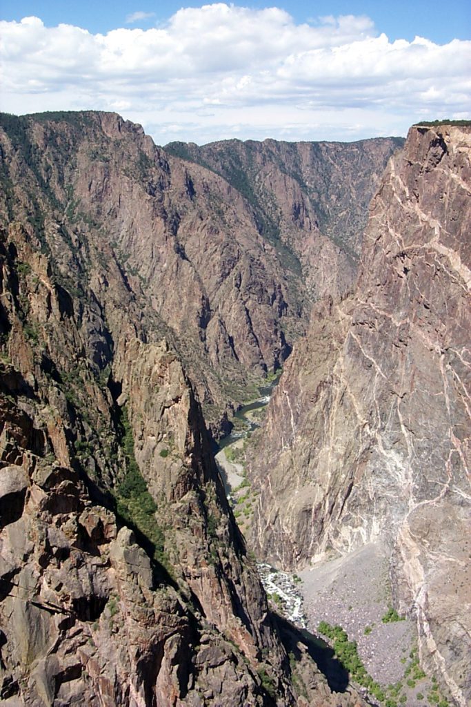 In this photo you can really see the pegamite dikes in the rock. The dikes are formed when the already cooled and hardened black basalt is broken and fractured by subsequent volcanic activity and the pegamite flows up into the cracks and, in turn, hardens.
