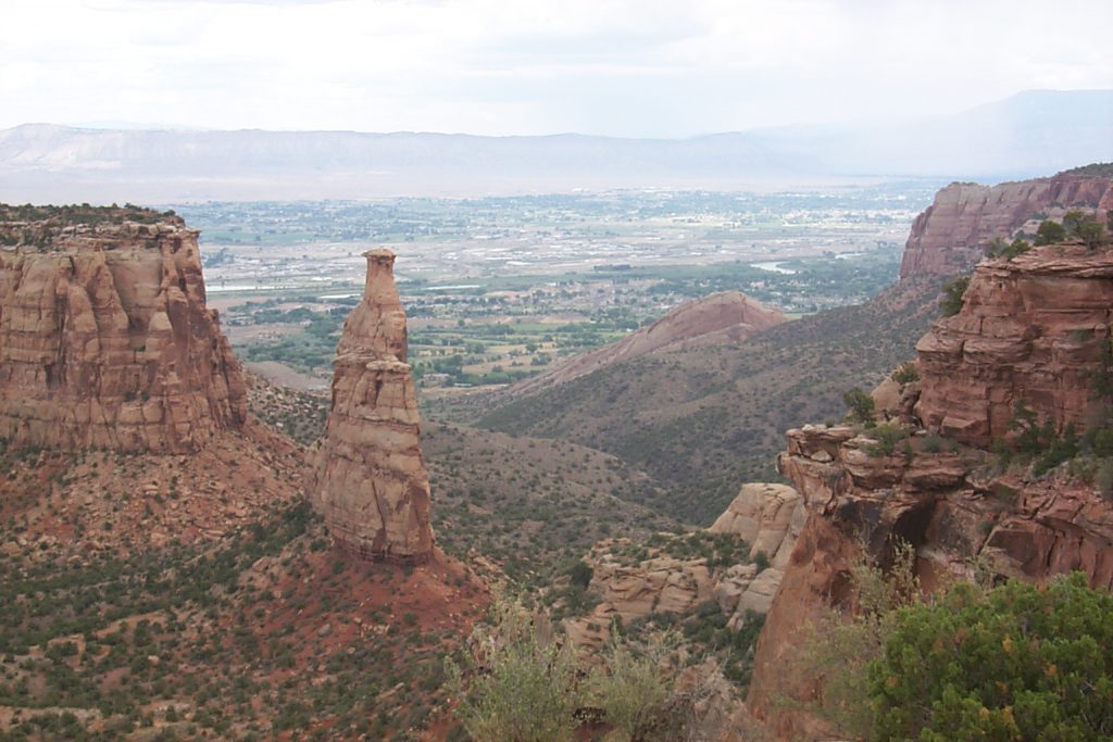 This photo shows the 'independence' fin. The fin is the remnant of a thin rock wall that originally extended from the far left to the far right. If you look closely you can see rain falling in the top right of the picture -- right over Grand Junction!