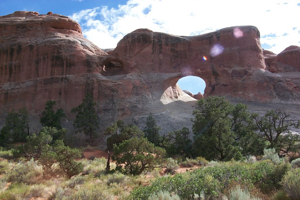 This is the 'Tunnel Arch'. If you look closely just to the left of the obvious tunnel arch you will see another arch. This is a 'pothole' arch which is created by a slightly different process -- namely water directly eroding a path out of a pothole in the surface of the rock above.